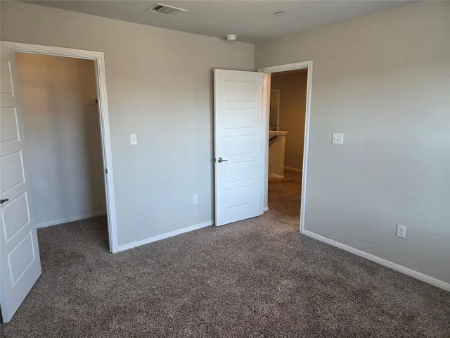 an empty room that has a grey walls and closet