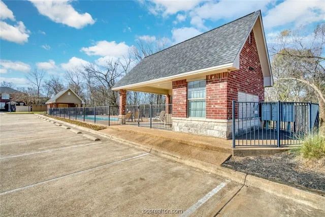 a brick house with a small yard and wooden fence