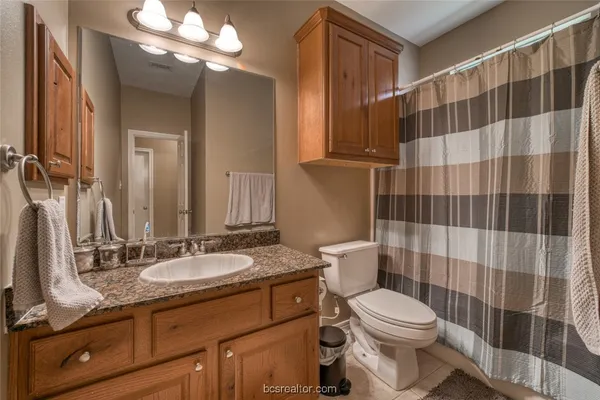 a bathroom with a sink a toilet a mirror and shower