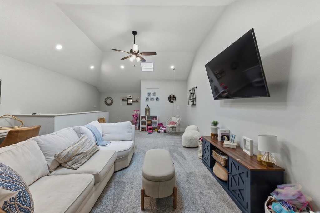 5425 Cherokee Draw Road Austin, TX 78738 - Photo 27 of 40 A vaulted ceiling, skylight, and recessed lighting illuminate this cozy living room, perfect for relaxation.