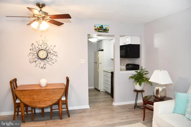 a living room with furniture a dining table and a refrigerator