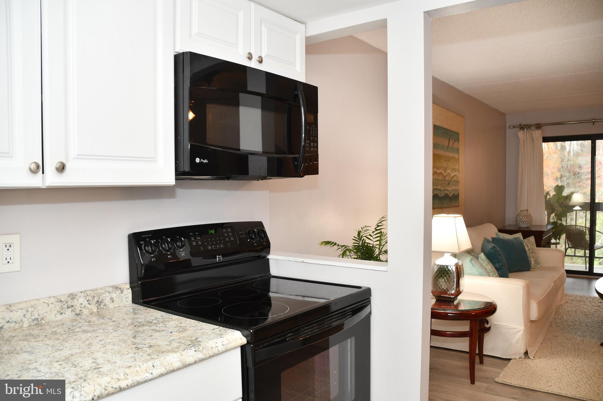 800 Avondale Road, Unit 7N Wallingford, PA 19086 - Photo 20 of 32 a kitchen with granite countertop white cabinets and black appliances