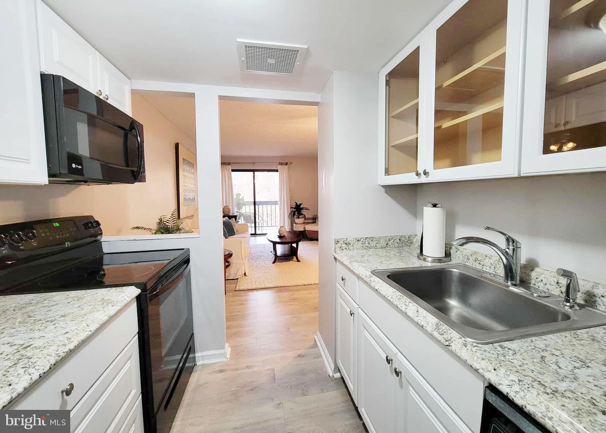 800 Avondale Road, Unit 7N Wallingford, PA 19086 - Photo 21 of 32 a kitchen with granite countertop a sink dishwasher stove and oven with wooden floor