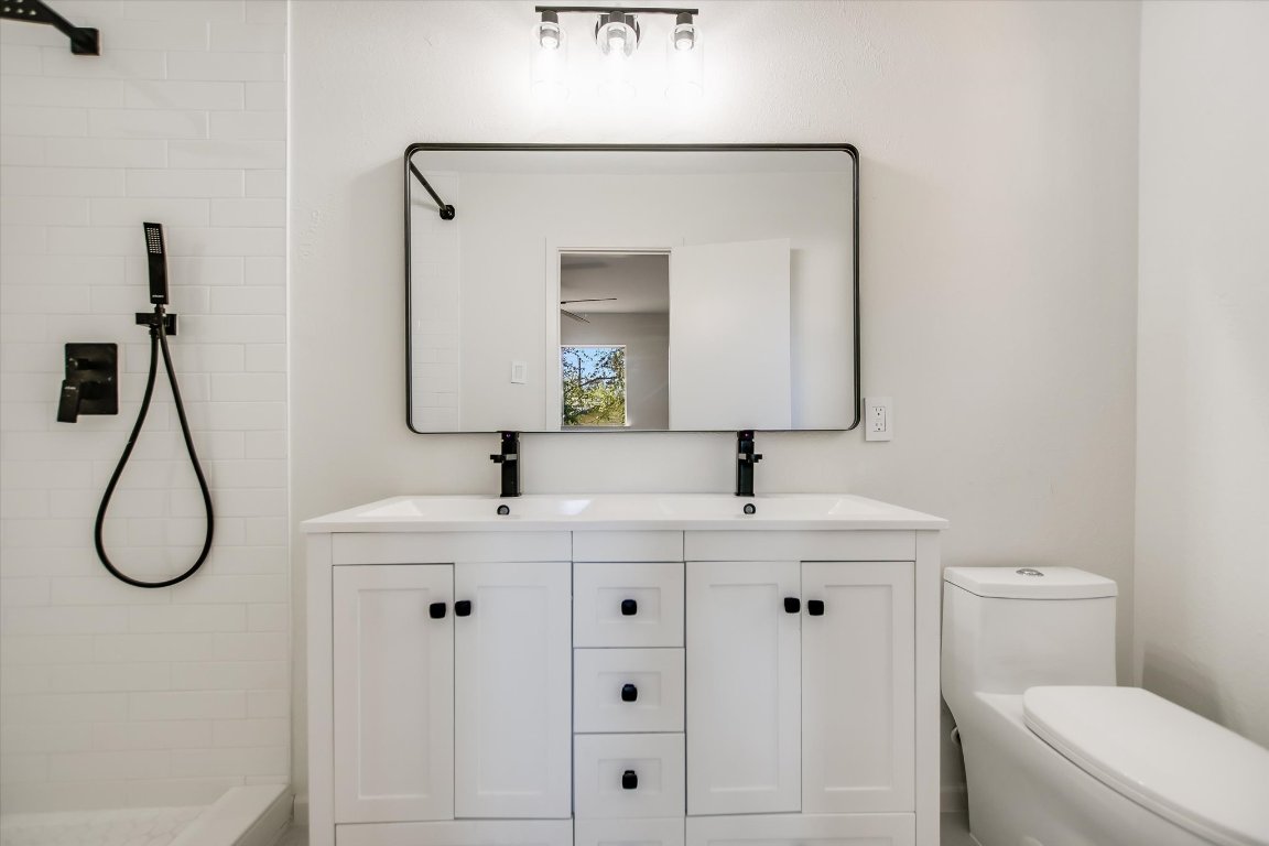 7003 Castlekeep Way Austin, TX 78745 - Photo 13 of 23 a bathroom with a toilet sink and mirror