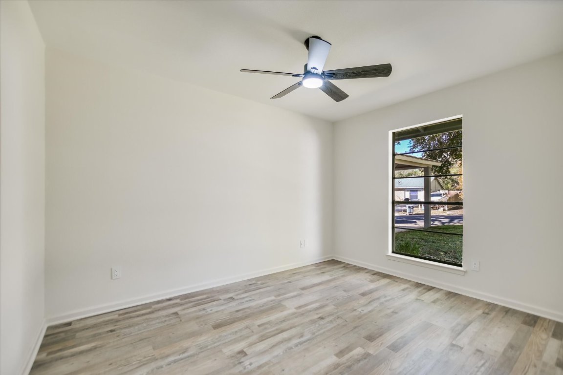 7003 Castlekeep Way Austin, TX 78745 - Photo 15 of 23 an empty room with wooden floor chandelier fan and windows