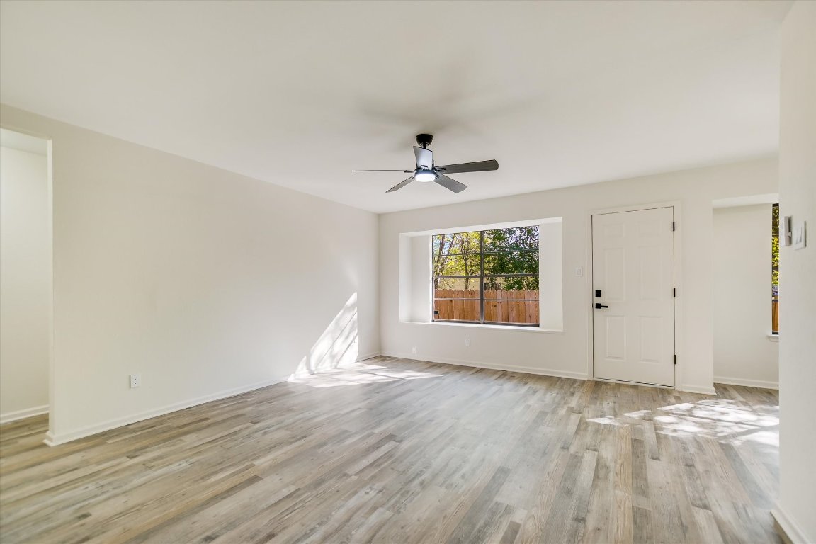 7003 Castlekeep Way Austin, TX 78745 - Photo 4 of 23 a view of an empty room with wooden floor and a window