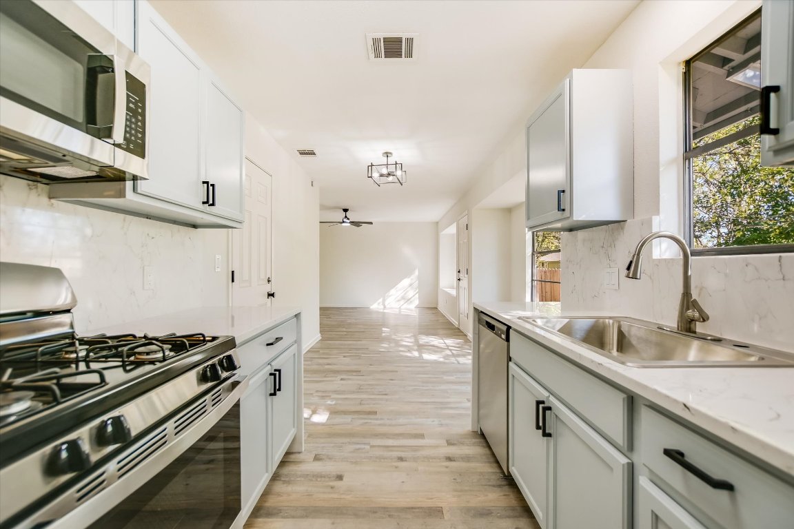 7003 Castlekeep Way Austin, TX 78745 - Photo 8 of 23 a kitchen with stainless steel appliances granite countertop a sink stove and cabinets