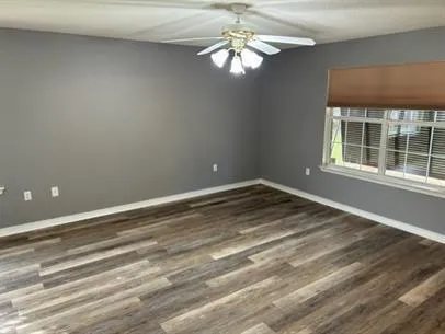 wooden floor in an empty room with a window