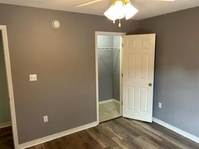 en empty room with wooden floor and chandelier fan