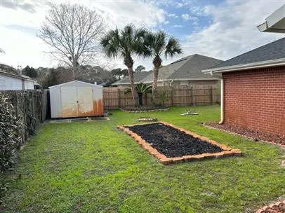 a view of a house with a yard and wooden fence