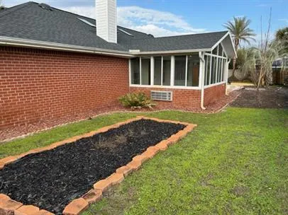 a view of a backyard with potted plants and large trees