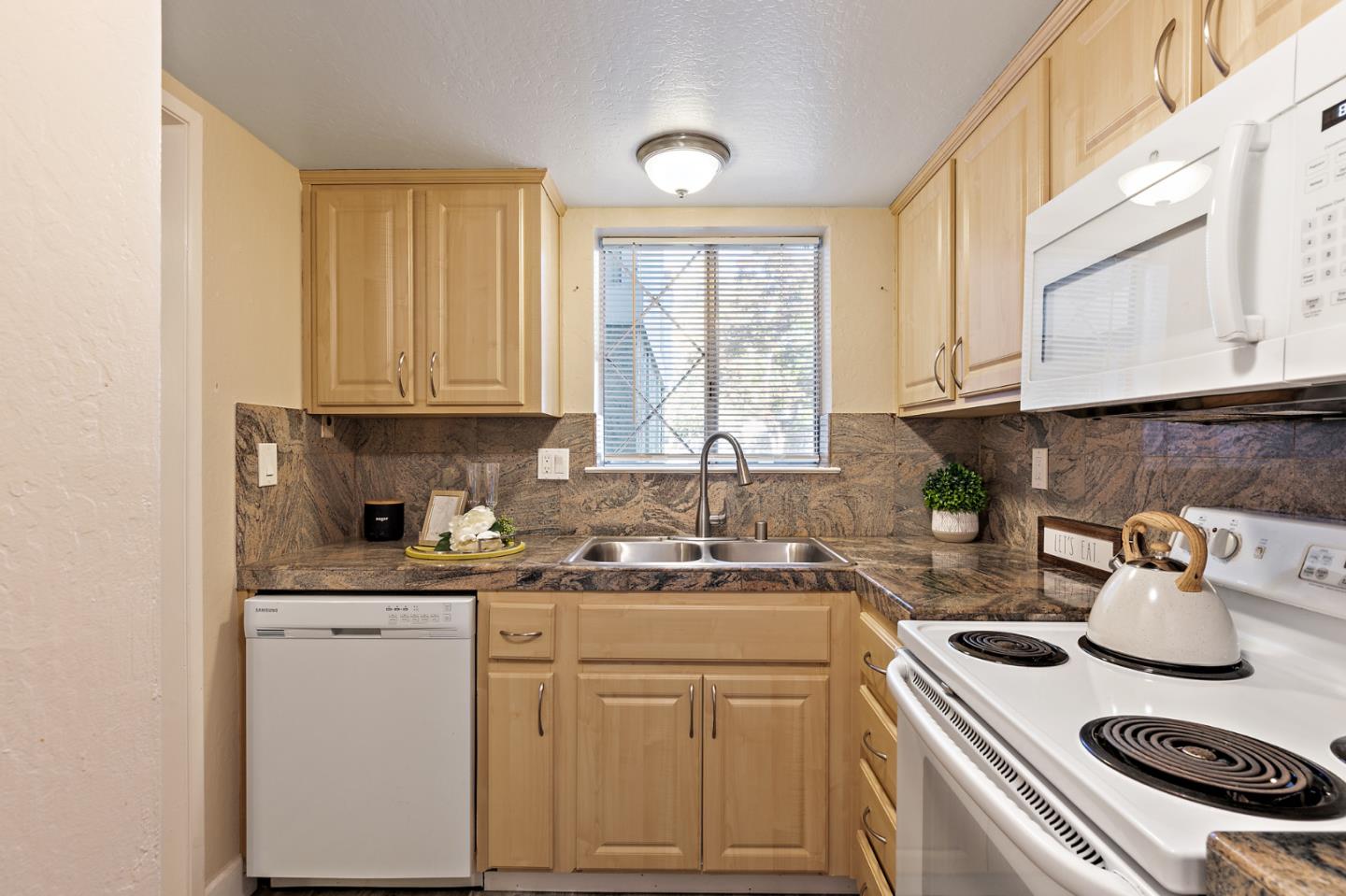 101 Redding Road, Unit A6 Campbell, CA 95008 - Photo 14 of 28 a kitchen with kitchen island granite countertop a sink a stove and cabinets