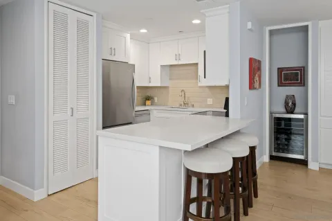 a kitchen with stainless steel appliances a table chairs refrigerator and microwave