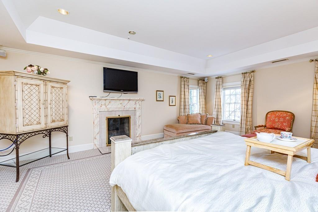 23 MacMillan Drive Concord, MA 01742 - Photo 28 of 41 a bedroom with a bed and a fireplace