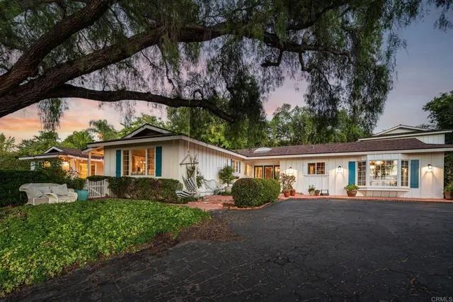 a view of a yard in front of a house with large tree