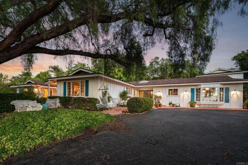 a view of a yard in front of a house with large tree