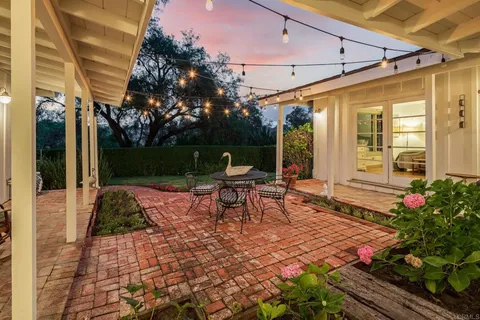 a view of a patio with table and chairs potted plants with wooden floor and fence