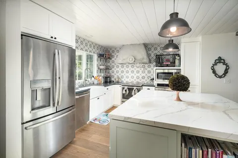 a view of a dining room with furniture large windows and wooden floor