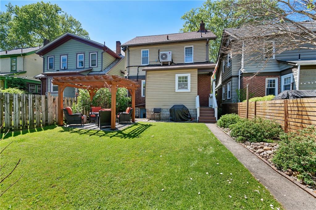 531 Peebles Street Pittsburgh, PA 15221 - Photo 23 of 30 a view of a house with a yard and lawn chairs with a fire pit