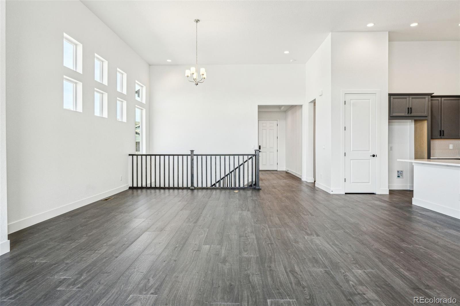 3884 Freestone Point Castle Rock, CO 80108 - Photo 12 of 34 a view of a hallway with wooden floor and a kitchen