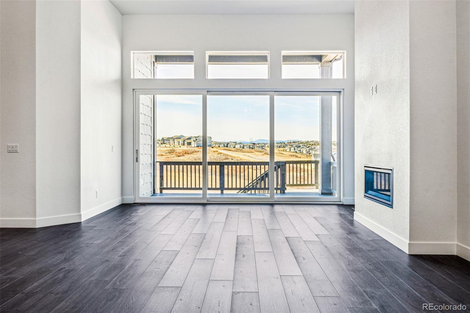 3884 Freestone Point Castle Rock, CO 80108 - Photo 9 of 34 a view of an empty room with wooden floor and a window