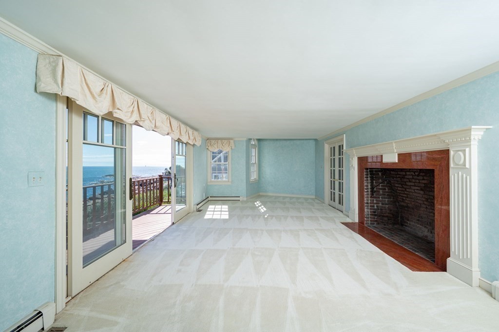 475 Jerusalem Road Cohasset, MA 02025 - Photo 10 of 41 a view of an empty room with glass door and a fireplace