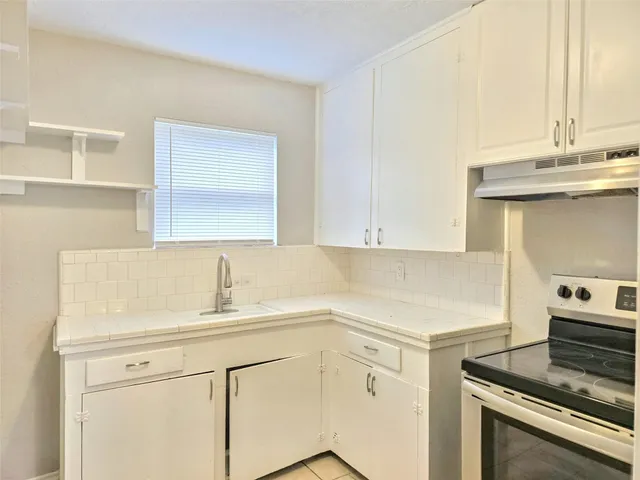 a kitchen with a sink cabinets and appliances