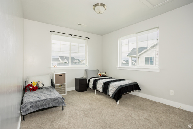 2452 West 500 South, Unit 2 Springville, UT 84663 - Photo 17 of 23 Spacious room featuring neutral paint, light-colored carpeting, two large windows with horizontal blinds, and a flush-mount ceiling light fixture