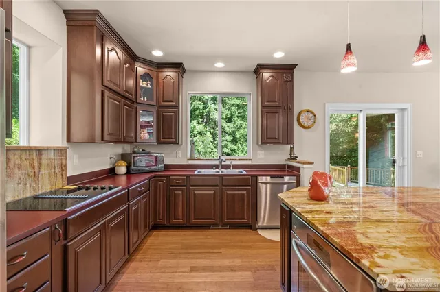 a kitchen with stainless steel appliances granite countertop a sink stove and cabinets