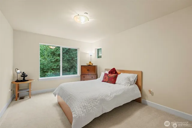 a bedroom with a bed and large window