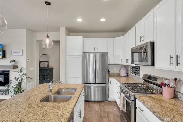 a kitchen with stainless steel appliances granite countertop a sink stove and refrigerator