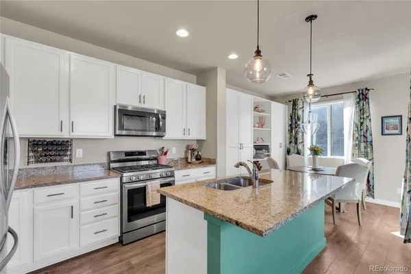 a kitchen with appliances cabinets and wooden floor