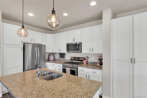 a kitchen with stainless steel appliances granite countertop a sink refrigerator and microwave
