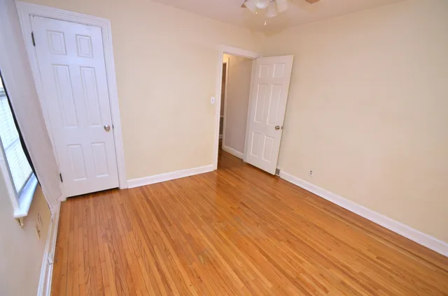 a view of an empty room with wooden floor