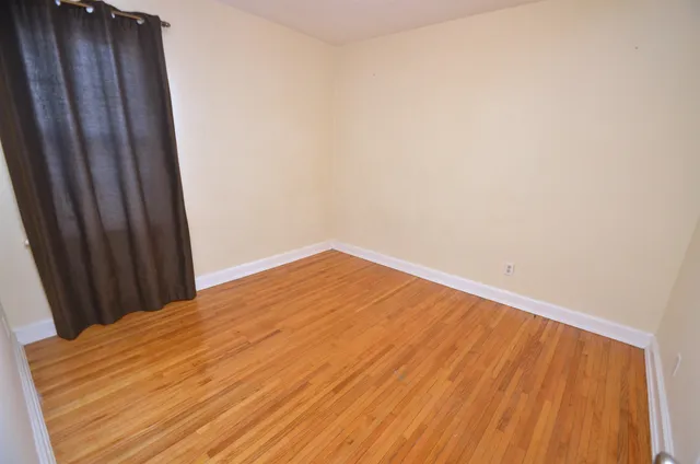 an empty room with wooden floor and sliding door