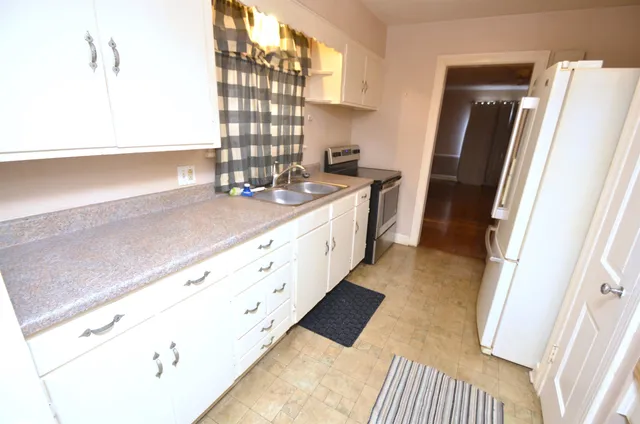 a view of a kitchen with a sink and refrigerator