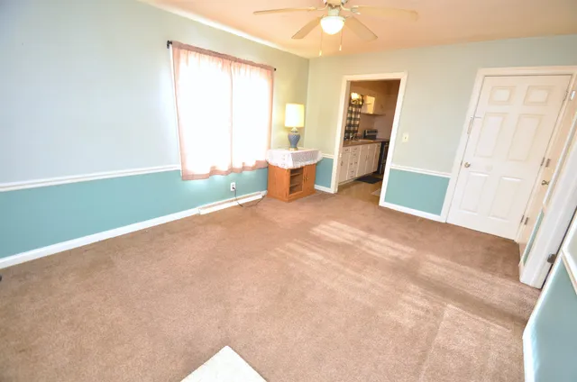 an empty room with wooden floor and a sink