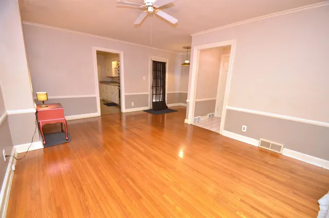 a view of empty room with wooden floor