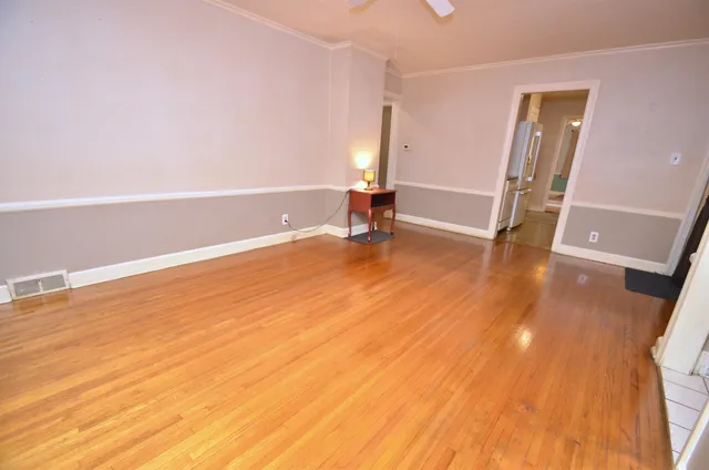 a view of empty room with wooden floor