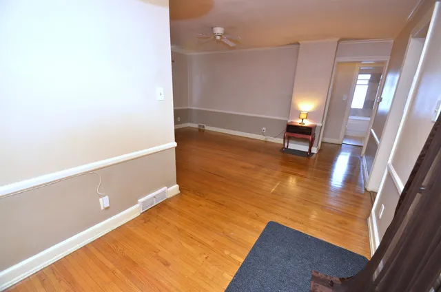a view of an empty room with wooden floor