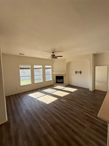 a view of empty room with wooden floor and fireplace