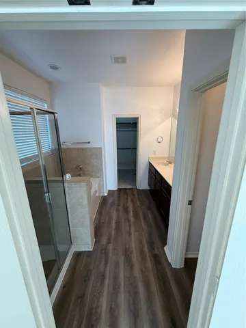 a walk in closet and hardwood floor