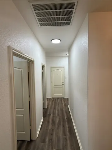 a view of hallway with wooden floor