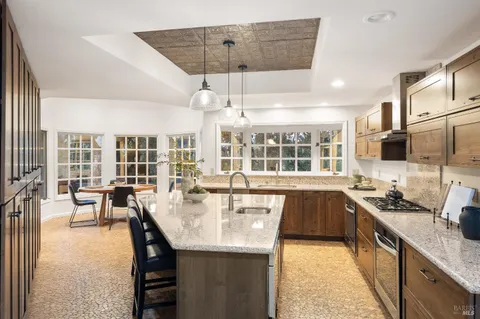 an open kitchen with granite countertop a stove and a sink