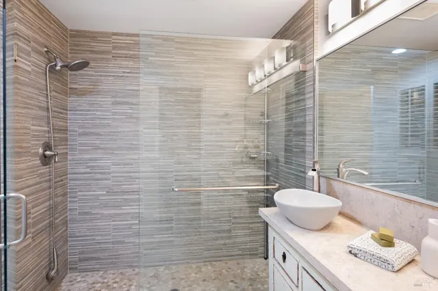 a bathroom with a sink a shower and a mirror