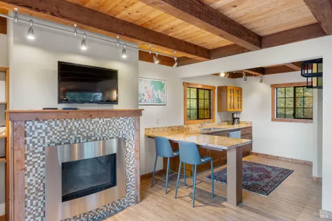 a living room with a table a flat screen tv and a fireplace