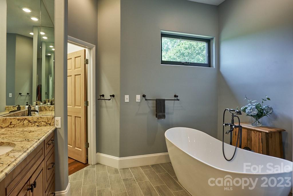 290 Stable Gate Drive Campobello, SC 29322 - Photo 27 of 39 a bathroom with a tub a sink and wooden floor