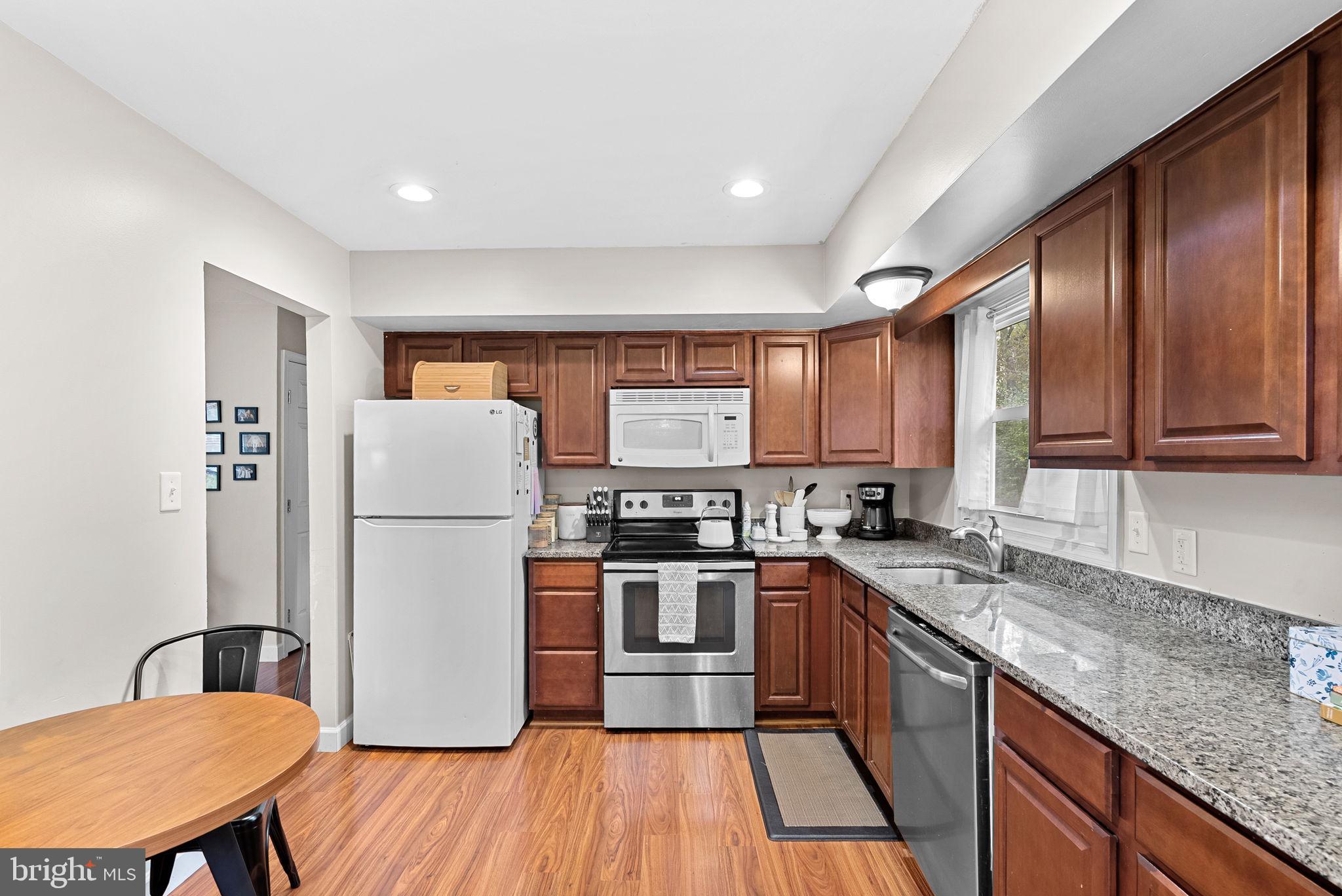 219 Josephine Street Berryville, VA 22611 - Photo 9 of 26 a kitchen with stainless steel appliances granite countertop a refrigerator a sink dishwasher a stove with wooden cabinets and floor