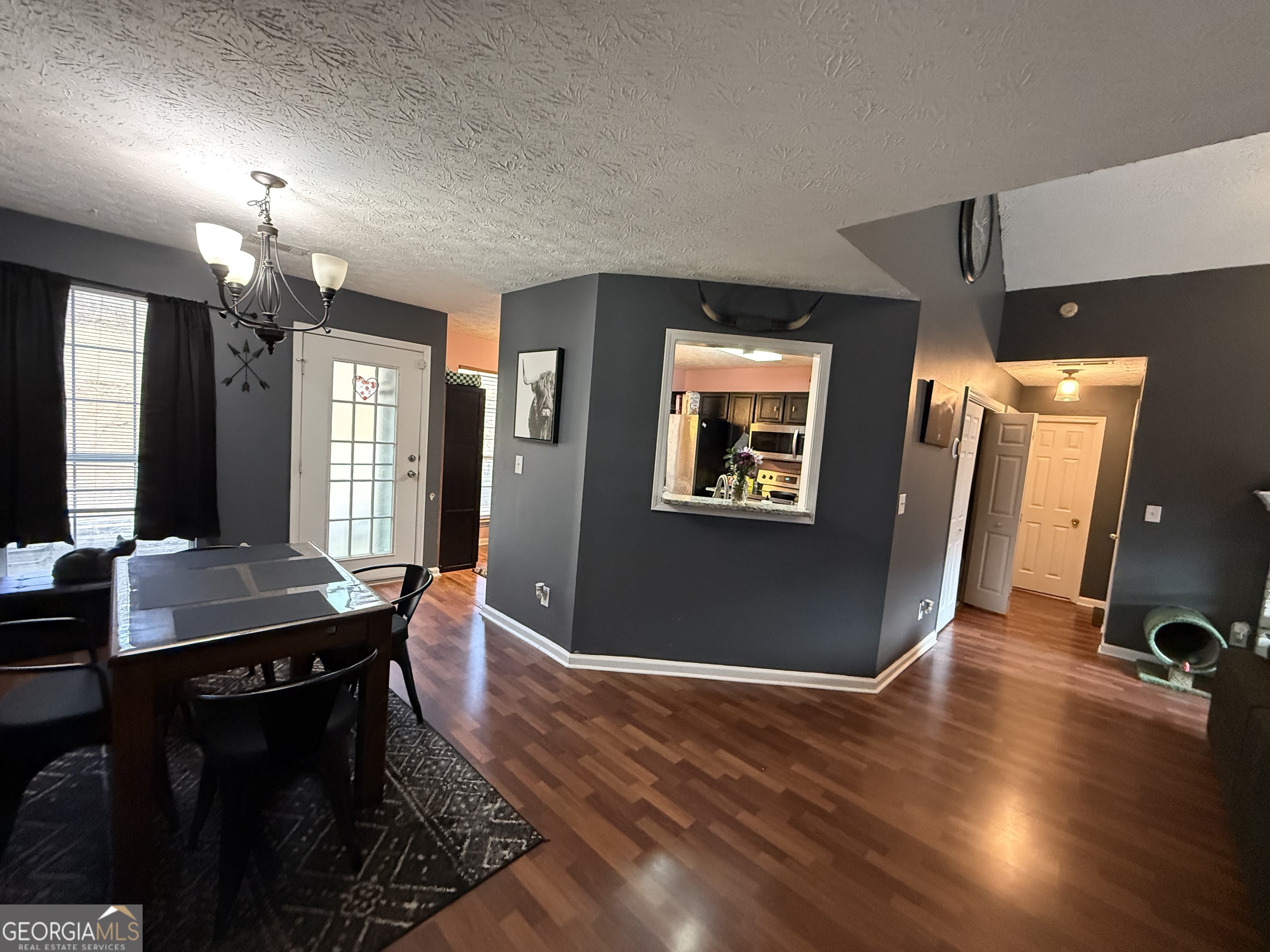 55 Jill Lane Covington, GA 30016 - Photo 8 of 52 a dining room with wooden floor a chandelier a wooden table and chairs