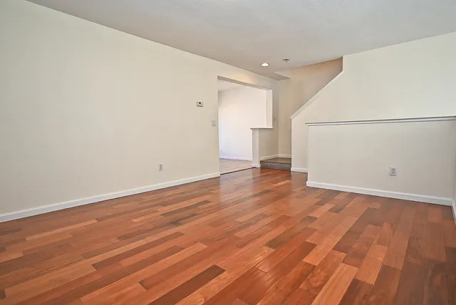 a view of an empty room with wooden floor